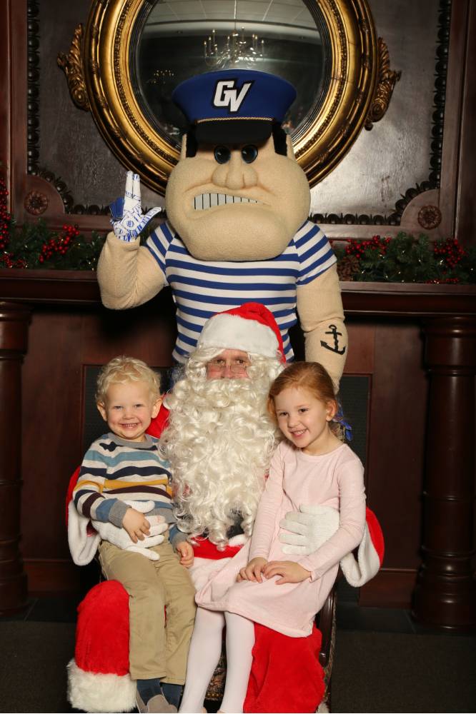 Alumni's two children posing with Santa and Louie the Laker
